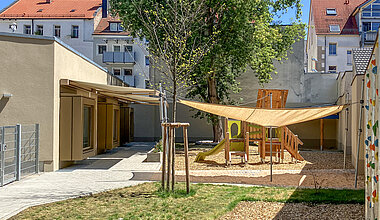 Kleine Riesen Nürnberg Rennweg - Außenbereich mit Klettergerüst, Sandkasten und Boulderwand