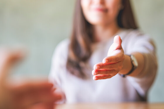 Erzieherin reicht Kind die Hand