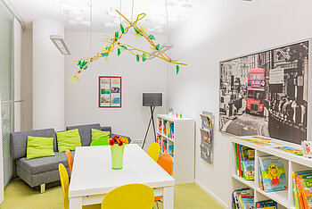 Teamzimmer mit Tisch und Couch der Kita Kleine Riesen München Schwabing