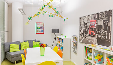 Teamzimmer mit Tisch und Couch der Kita Kleine Riesen München Schwabing