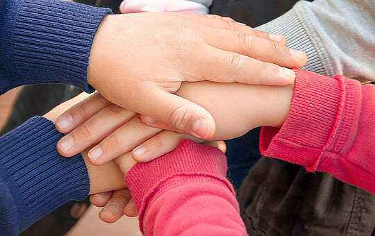 Detail der Hände von Kindern, die in einem europäischen Park spielen.
