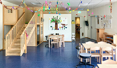Kita Kleine Riesen Hannover Badenstedt - Kindergartenraum mit Spielturm und Tischen