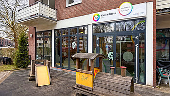 Kleine Riesen Hamburg Lokstedt - Außenfläche mit Holzzug und Gebäude