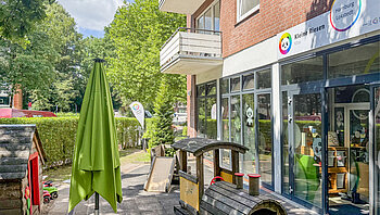 Kleine Riesen Hamburg Lokstedt - Außenfläche mit Holzzug und Gebäude