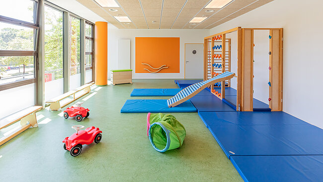 Turnraum mit Spielgräten und Klettergerüst der Kita Kleine Riesen München Schwabing