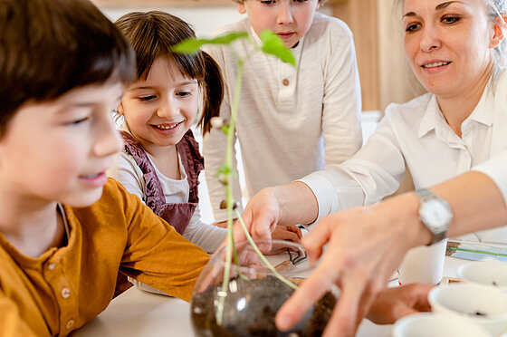 Kinder haben großes Reagenzglas mit Blume in der Hand