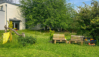 Grüner Garten mit Sitzgelegenheiten der Kita Kleine Riesen Magdeburg