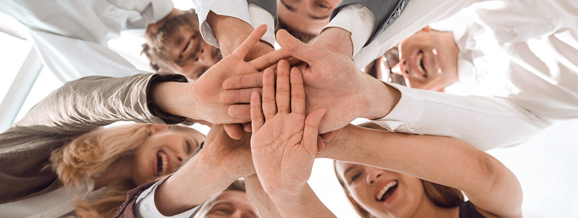 Gruppe von Personen die die Hände zusammenhalt