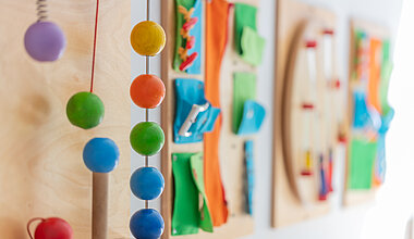 An der Wand hängende Holzspielzeuge der Kita Kleine Riesen München Schwanthalerhöhe