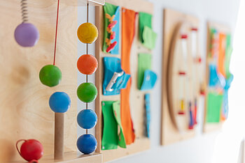 An der Wand hängende Holzspielzeuge der Kita Kleine Riesen München Schwanthalerhöhe