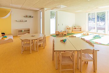 Gruppenraum mit Tischen der Kita Kleine Riesen München Neuperlach-Zentrum