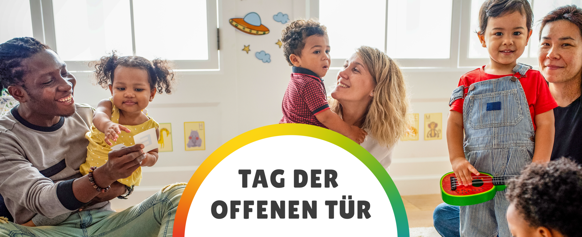 glückliche Eltern sitzen mit Kindern auf dem Boden in der Kita mit Schriftzug "Tag der offenen Tür"