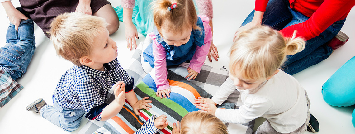 Kinder die auf dem Boden spielen